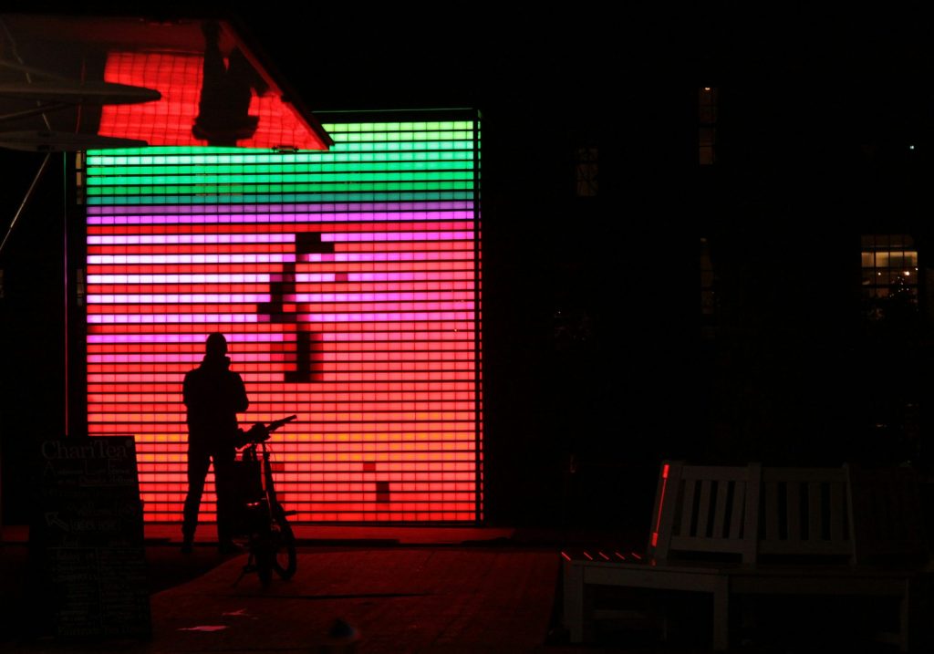 a person standing in front of a colorful wall